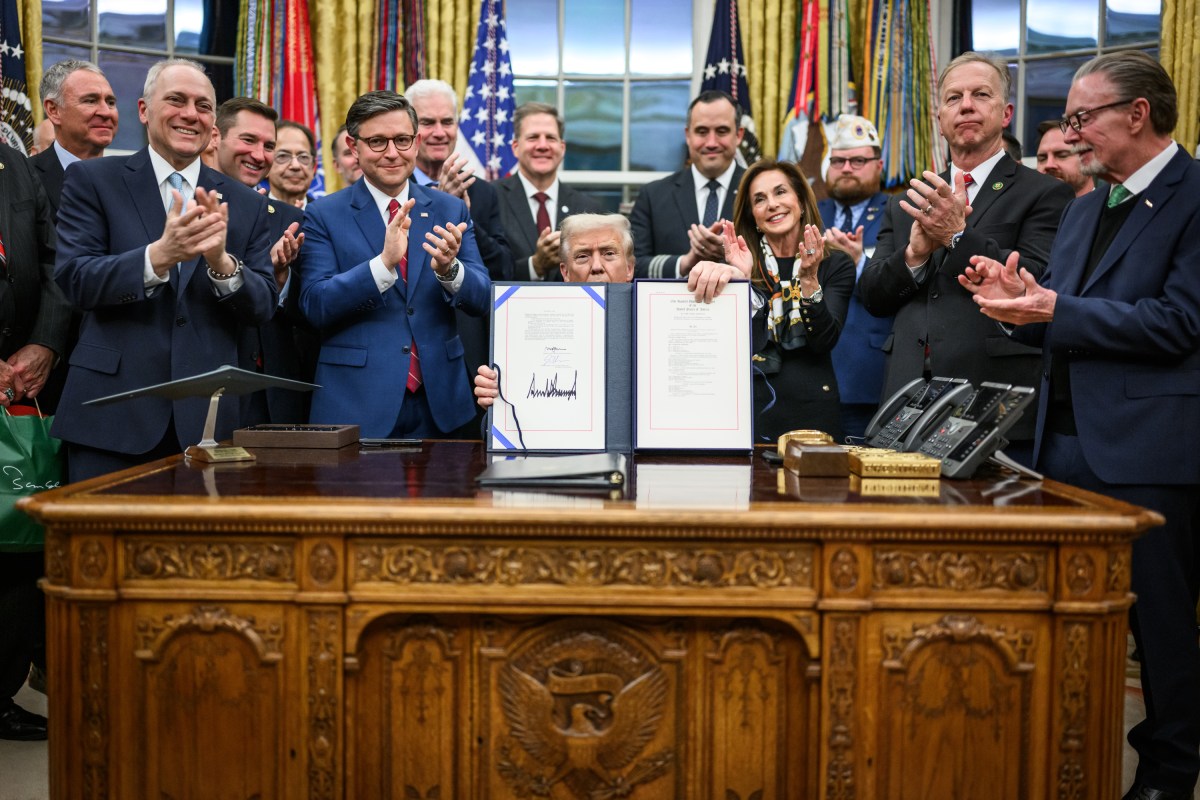 President Donald Trump shows members of the media the signed bill from Congress that reopens the government, Wednesday, November 12, 2025, in the Oval Office. (Official White House Photo by Daniel Torok)